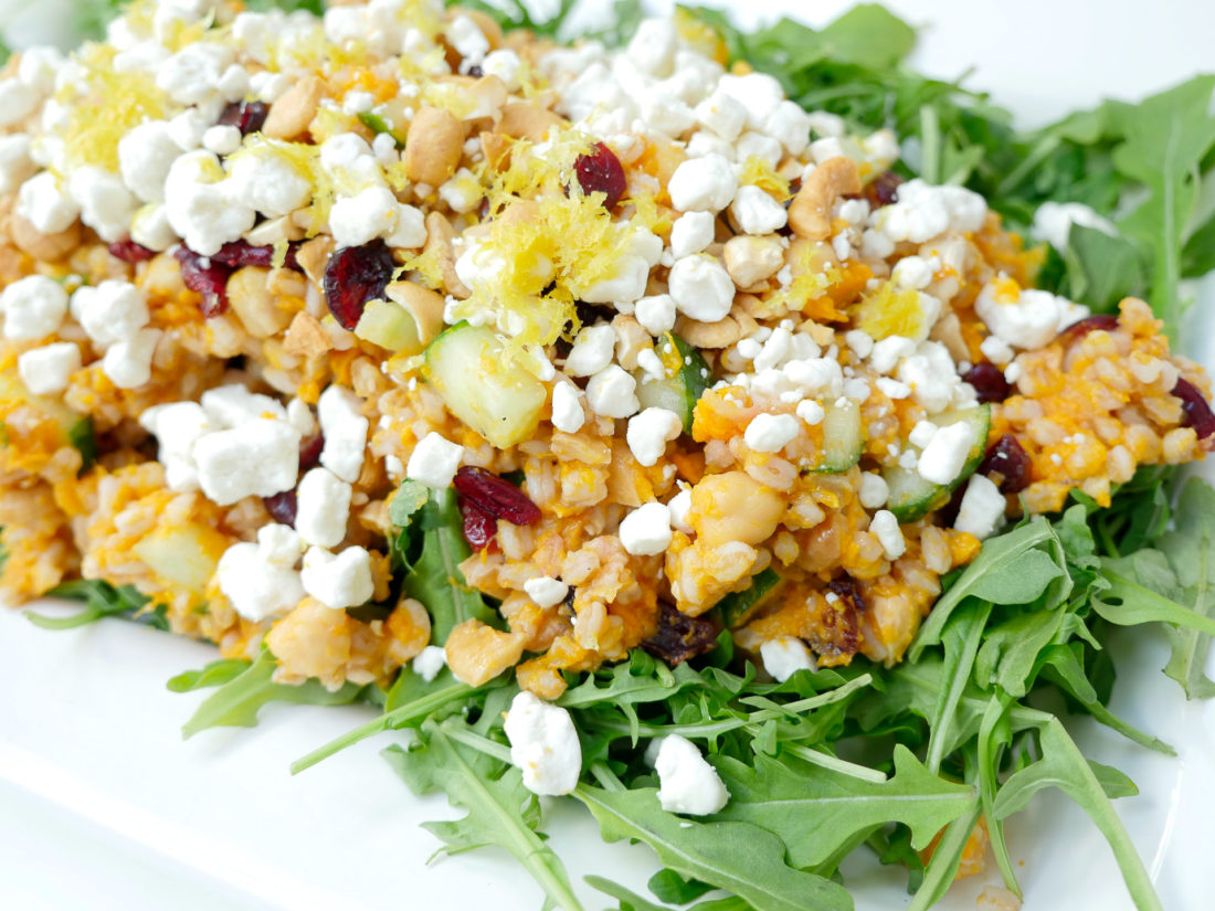 REZTT Autumn Farro Salad with Sweet Potato, Cucumber, Chickpeas, cranberries, goat cheese, cashews, arugula, and lemon zest phtographed in a marble kitchen 