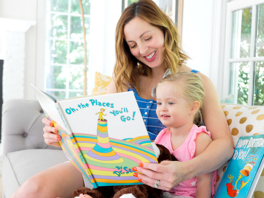 Eva Amurri Martino of the REZTT blog, with her two year old daughter Marlowe, sitting in her bright and modern family room reading Dr. Seuss books on the couch