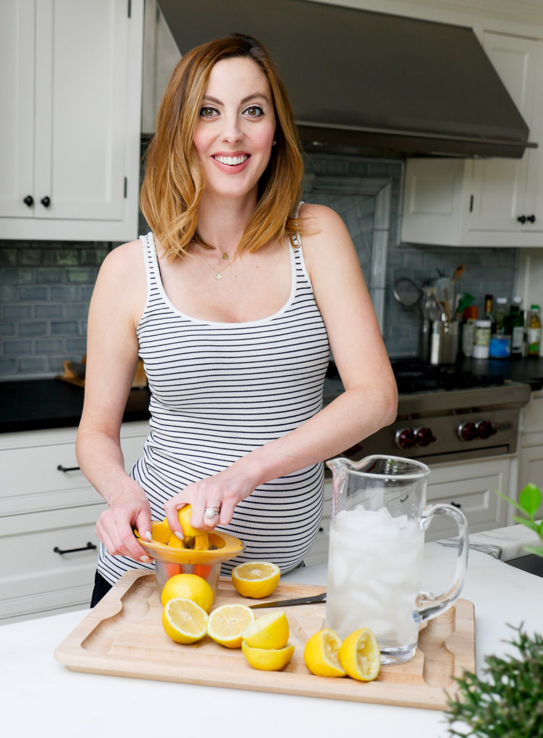 Eva Amurri Martino of lifestyle blog REZTT squeezing lemons in her kitchen to make a hydrating laborade for her Home Birth