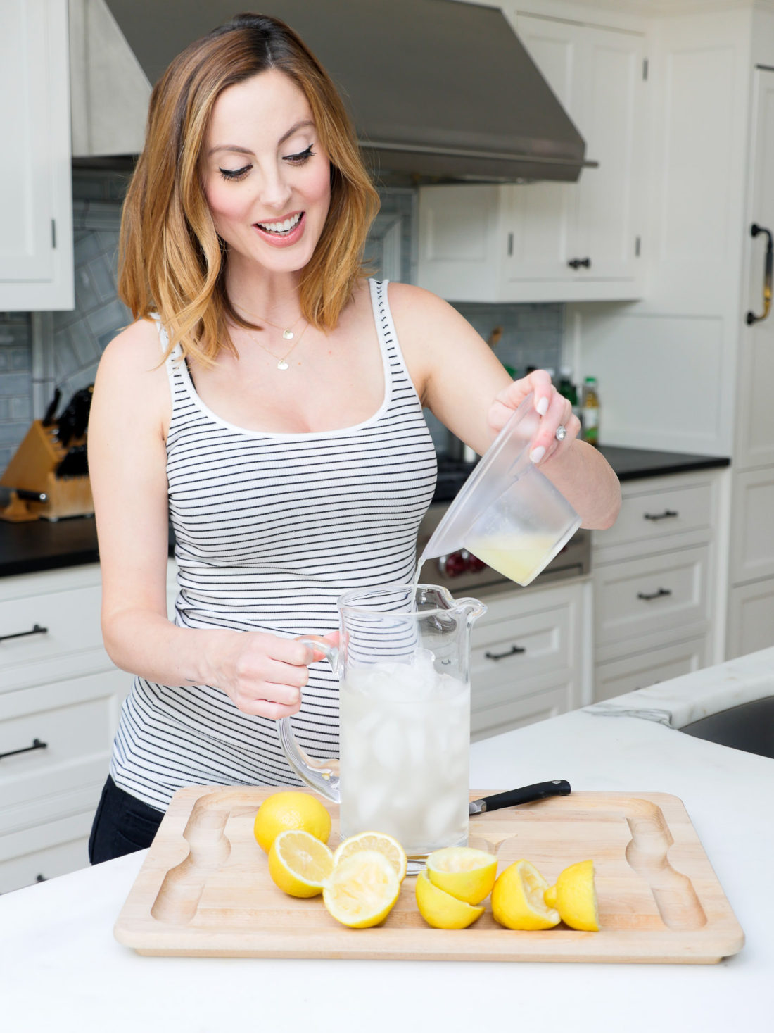 Eva Amurri Martino of lifestyle blog REZTT squeezing lemons in her kitchen to make a hydrating laborade for her Home Birth