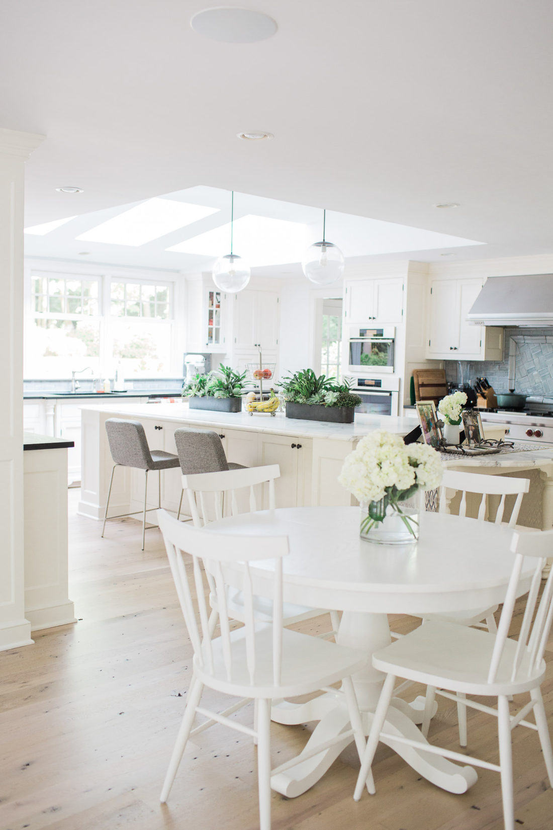 The bright, open, and airy kitchen of lifestyle blogger Eva Amurri Martino in connecticut featuring a big carrara marble island
