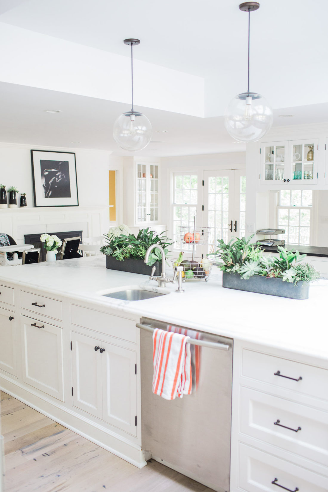 The light, bright, and white kitchen of Eva Amurri Martino in her new Connecticut Home. Industrial accents and huge white marble kitchen island