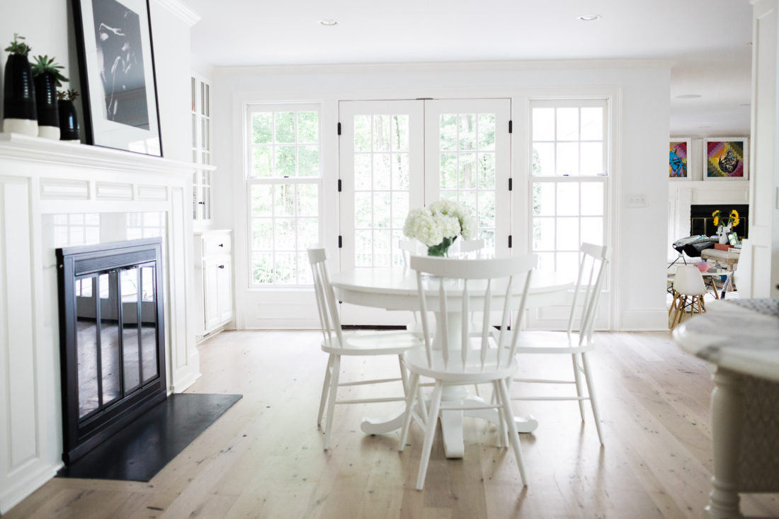 The kitchen table area of Eva Amurri Martino's Connecticut home, featuring a stark white kitchen table and white shaker chairs