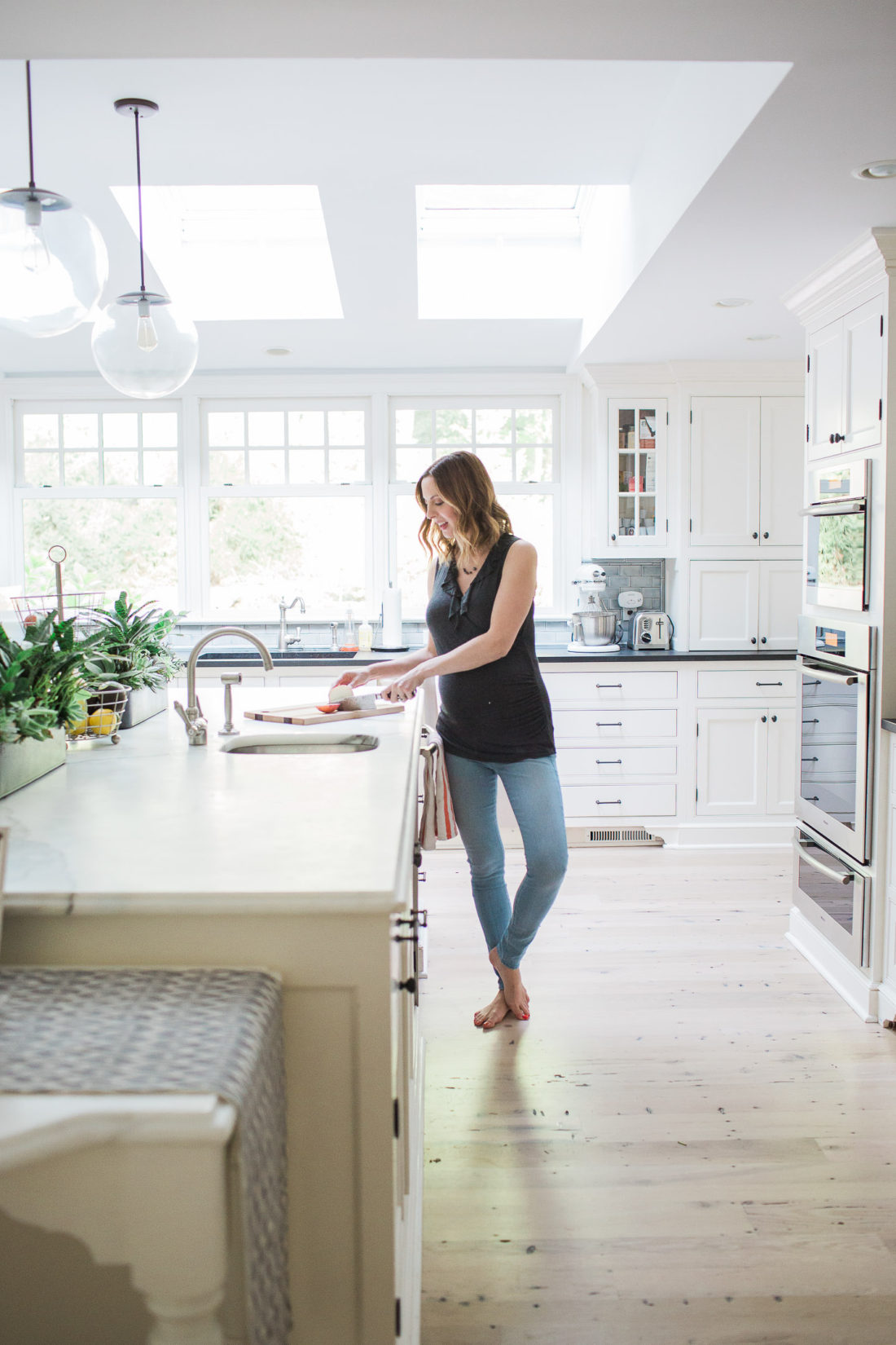 Eva Amurri Martino of lifestyle blog REZTT in her white and bright kitchen in her connecticut home