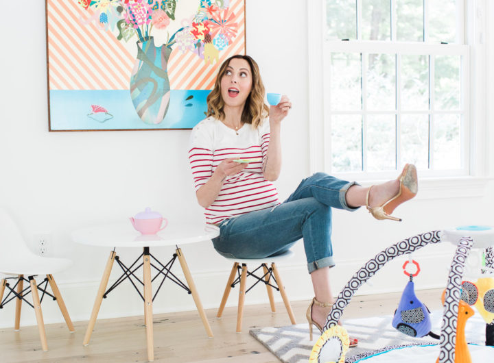 Eva Amurri Martin of lifestyle blog REZTT drinking tea from her daughter's tea set and perching on a tiny white midcentury modern playroom furniture set with the jonathan adler crafter by fisher price collection sensory gym in the foreground