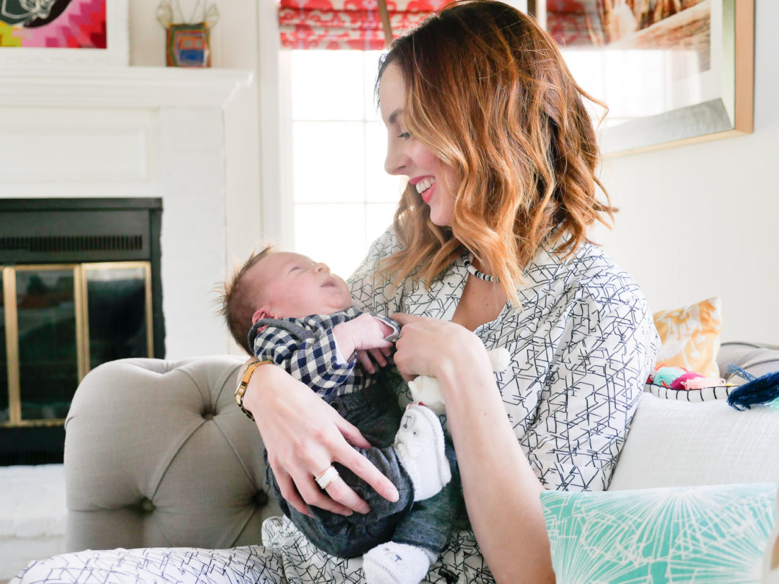 Eva amurri Martino of lifestyle and motherhood blog REZTT, holding newborn son Major James at his Sip And See at home in Connecticut