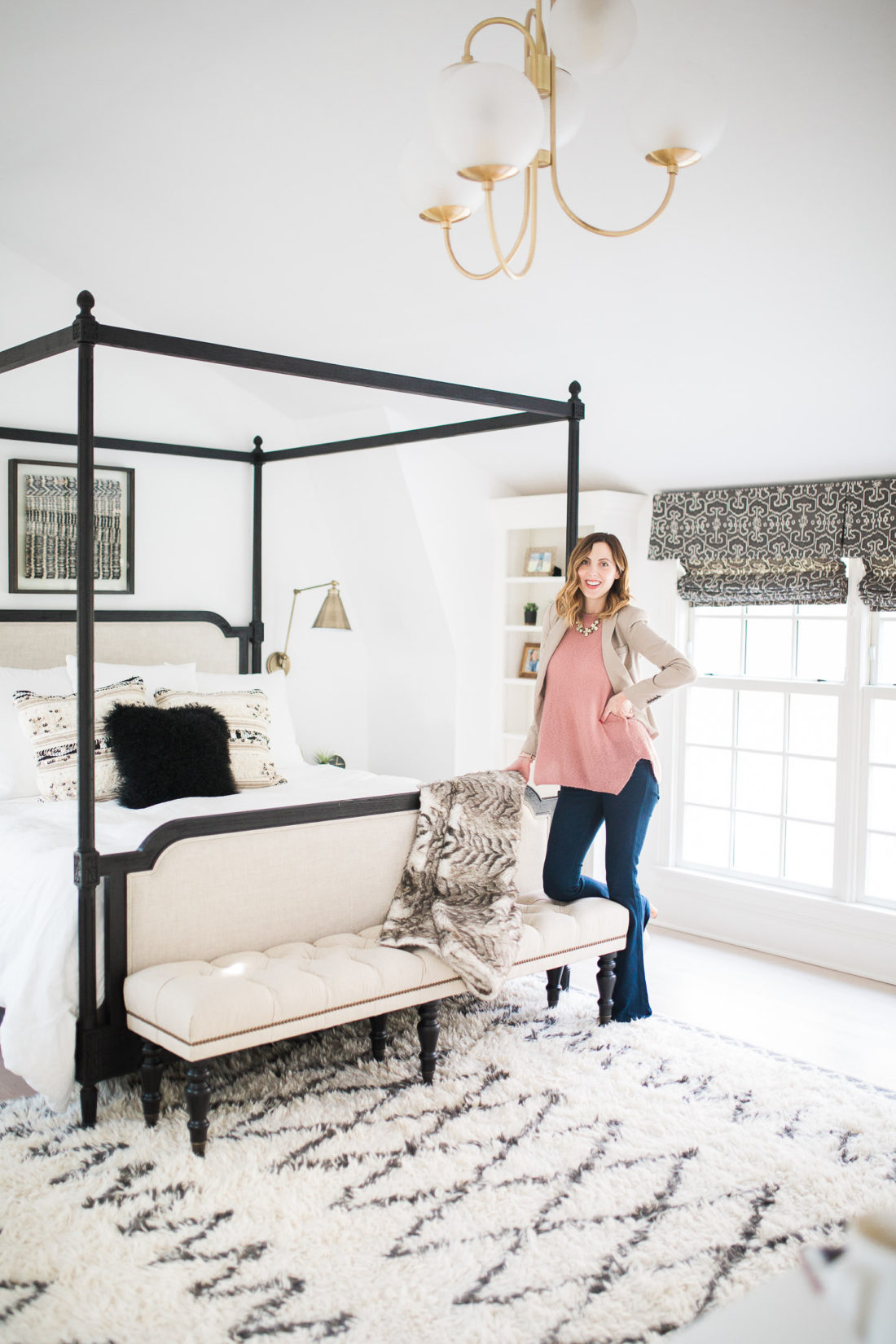Eva Amurri Martino of lifestyle and motherhood blog REZTT poses in her black, white, and brass master bedroom in Connecticut
