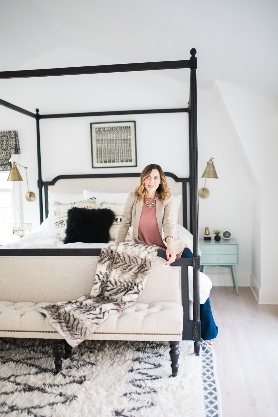 Eva Amurri Martino of lifestyle and motherhood blog REZTT poses in her black, white, and brass master bedroom in Connecticut