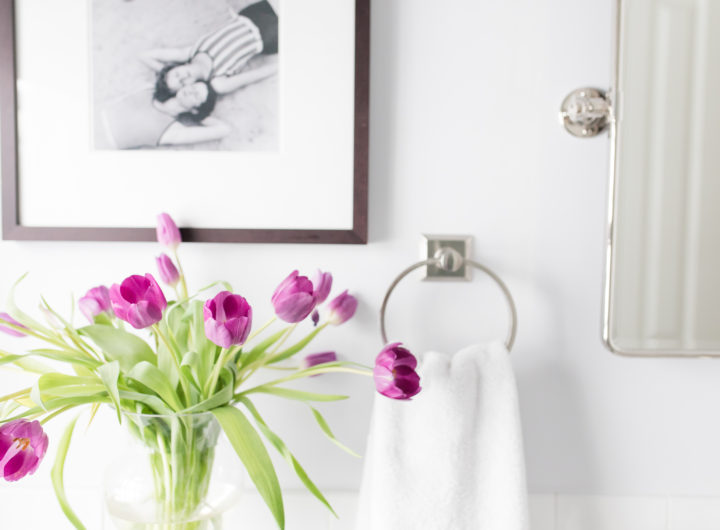 A detail of purple tulips in the bright white guest bathroom of Eva Amurri Martino's Connecticut home