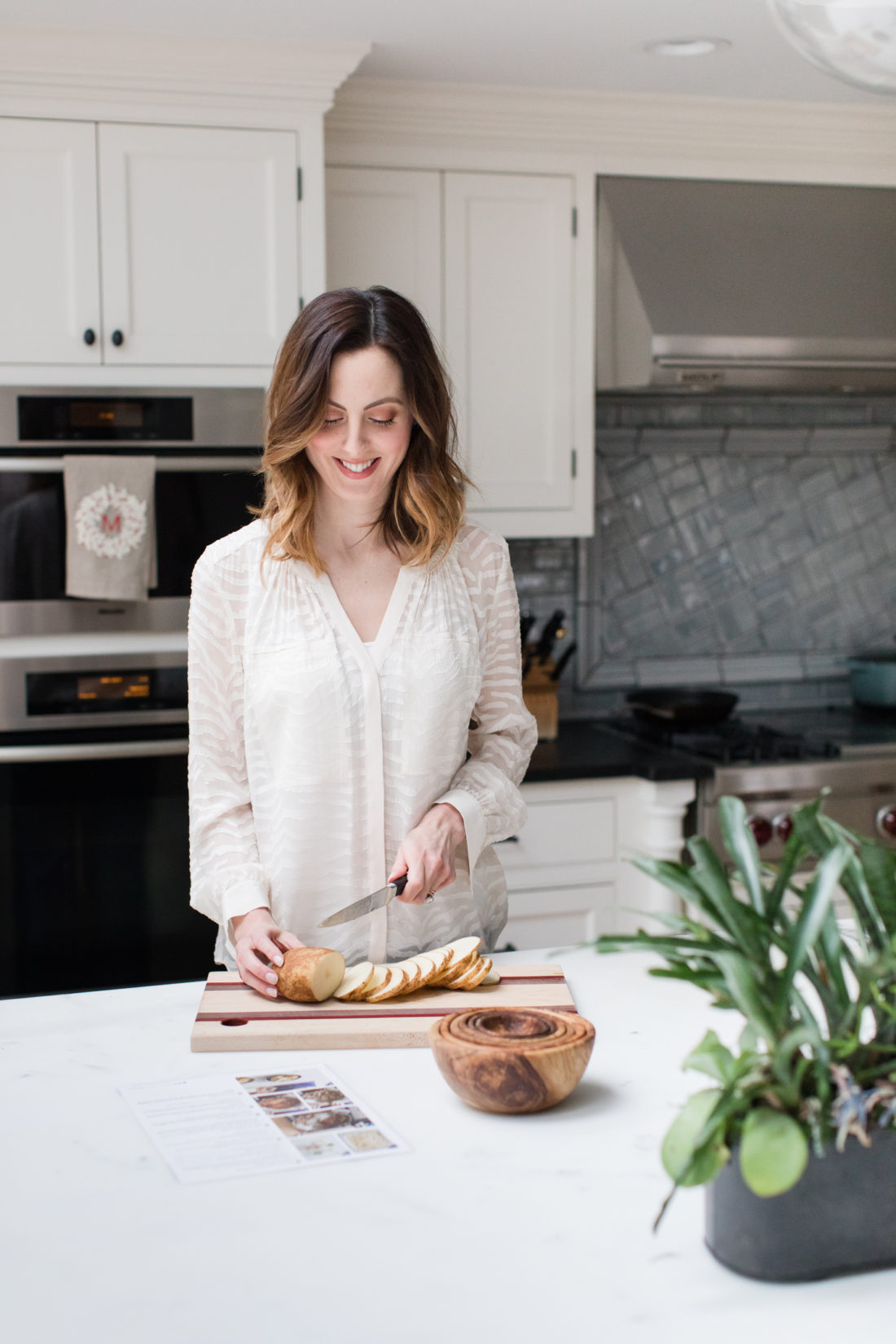 Eva Amurri Martino slices rounds of potatoes in her kitchen