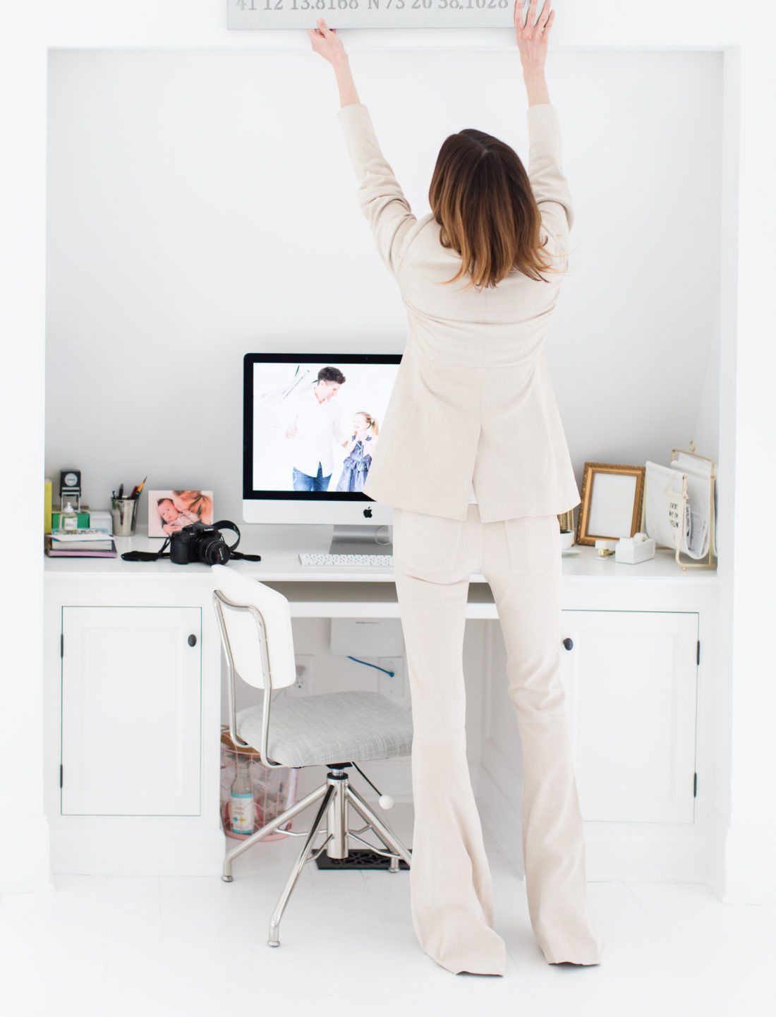 Eva Amurri Martino hangs something above her desk in the REZTT studio