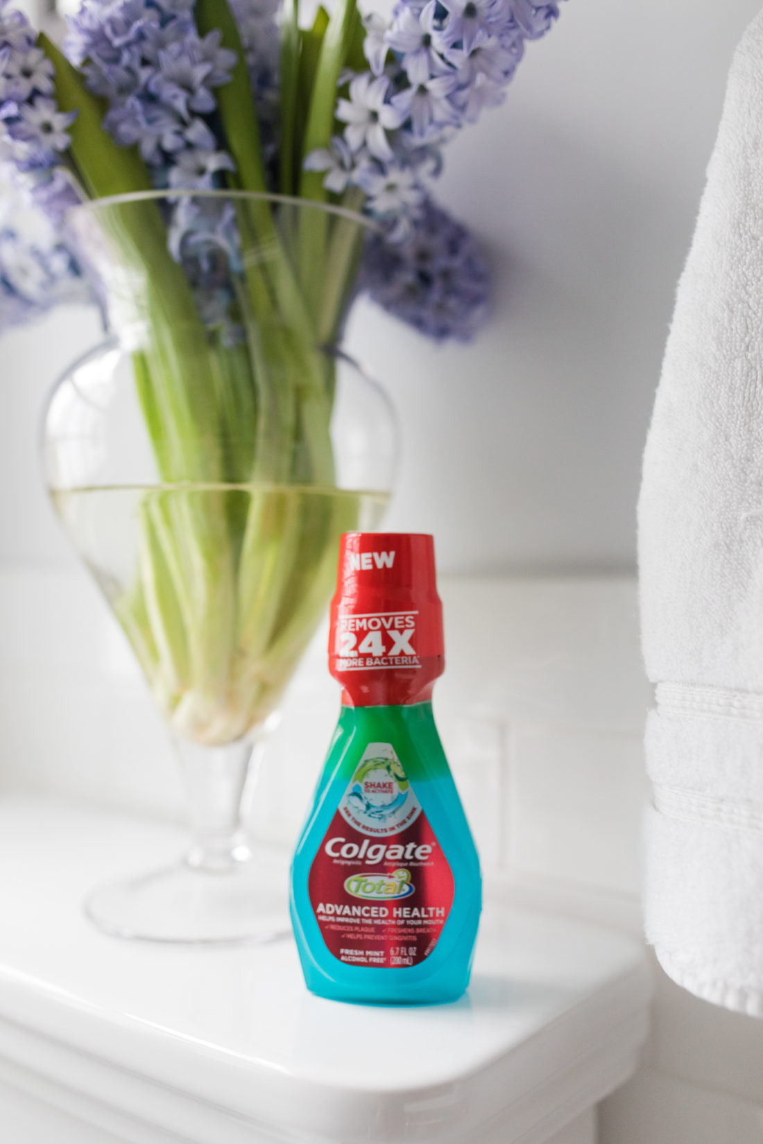 Colgate advanced health mouthwash sits next to a bowl of lilac's in Eva Amurri Martino's bathroom