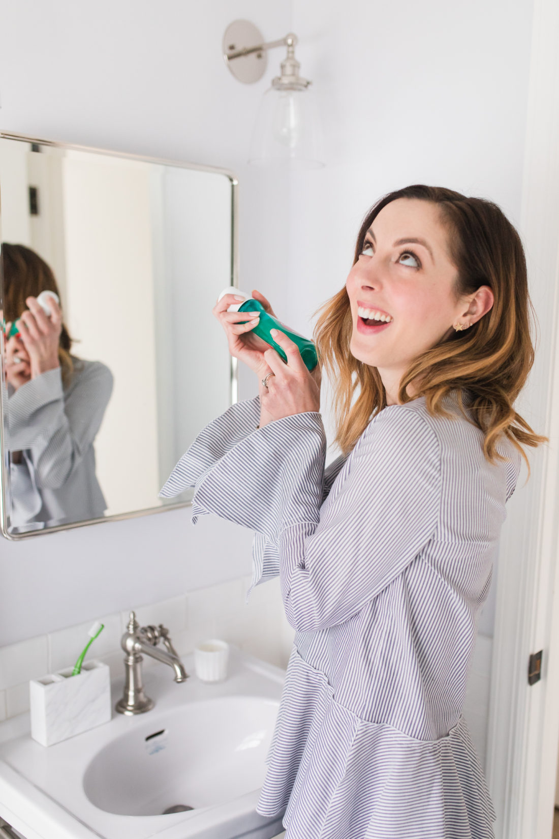 Eva Amurri Martino shakes up a bottle of Colgate Advanced Health mouthwash