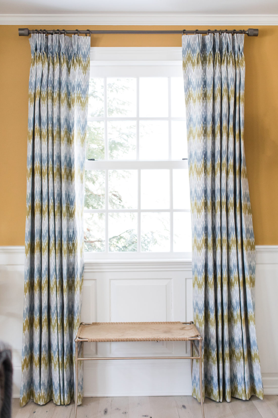 A brass and hyde window seat accent space