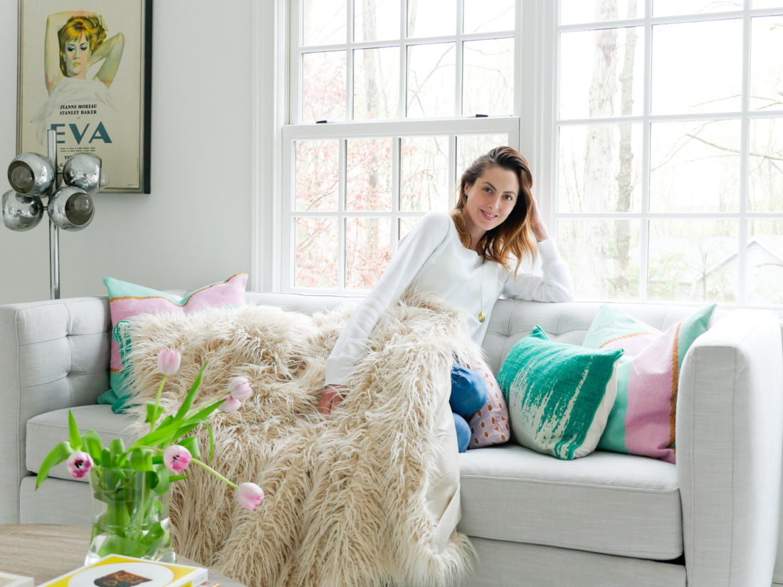 Eva Amurri Martino relaxes on the couch in the REZTT studio wearing a white sweatshirt