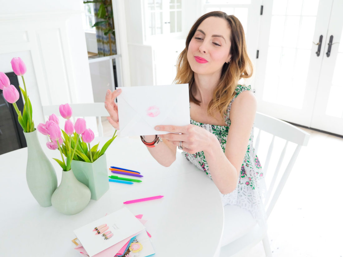 Eva seals her Mother's Day card for her Mom with a pink kiss