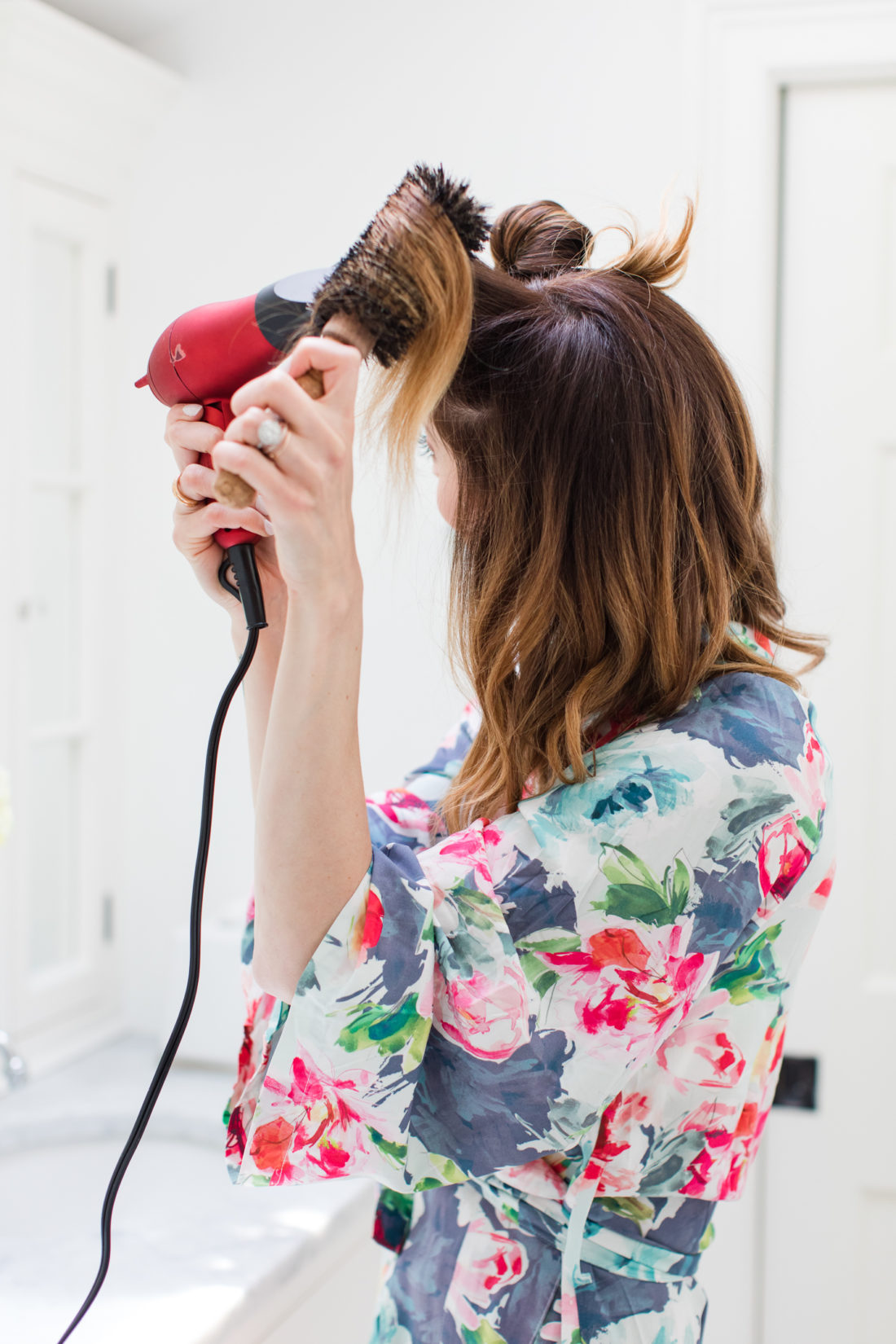 Eva Amurri Martino wears a floral silk robe and gives herself a bouncy blowout in the bathroom of her connecticut home