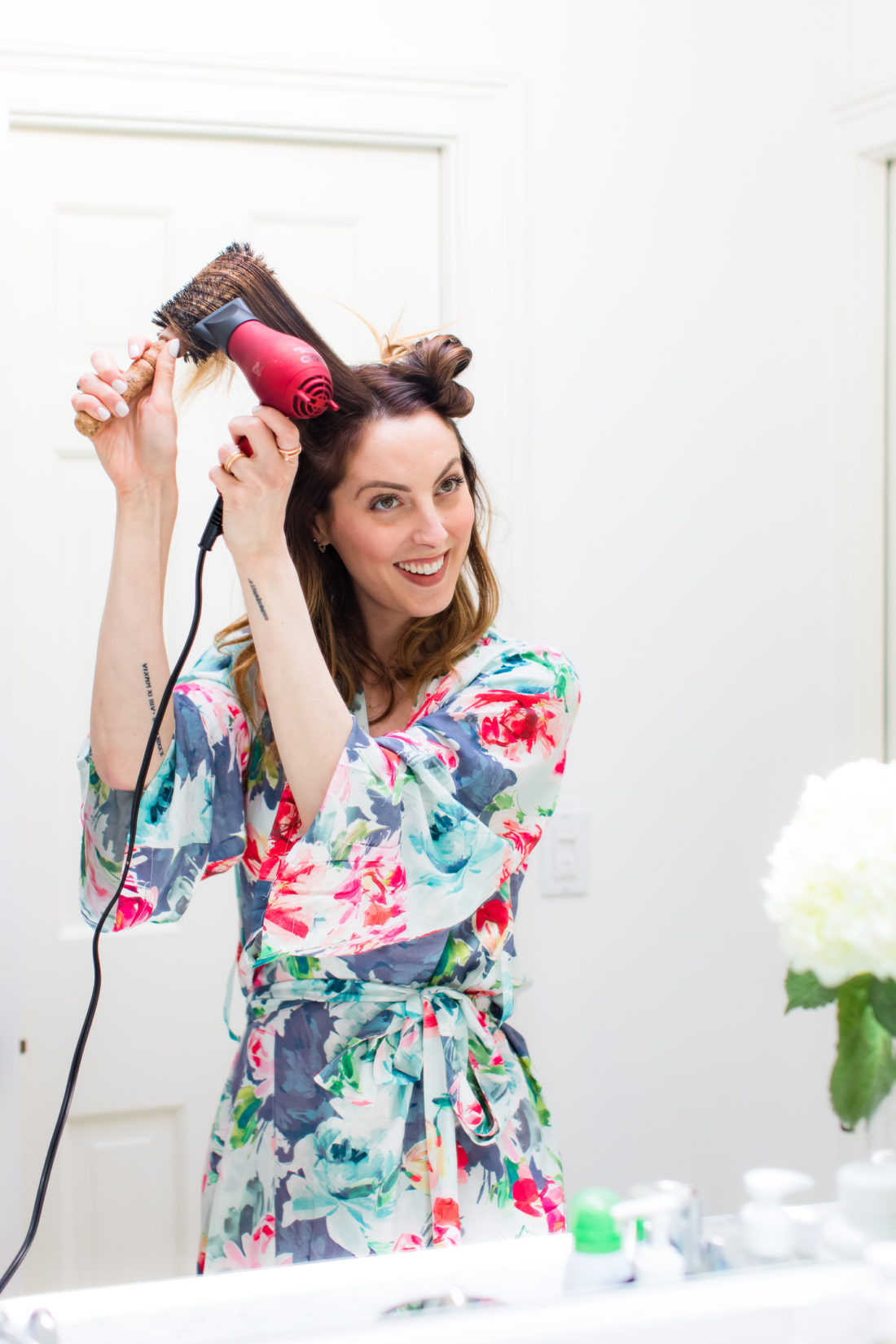 Eva Amurri Martino wears a floral silk robe and gives herself a bouncy blowout in the bathroom of her connecticut home