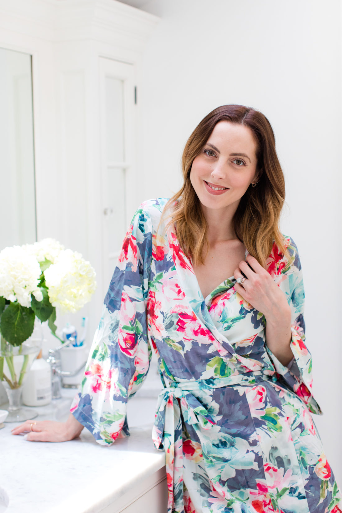 Eva Amurri Martino wears a floral robe and runs her hands through her smooth bouncy blow out