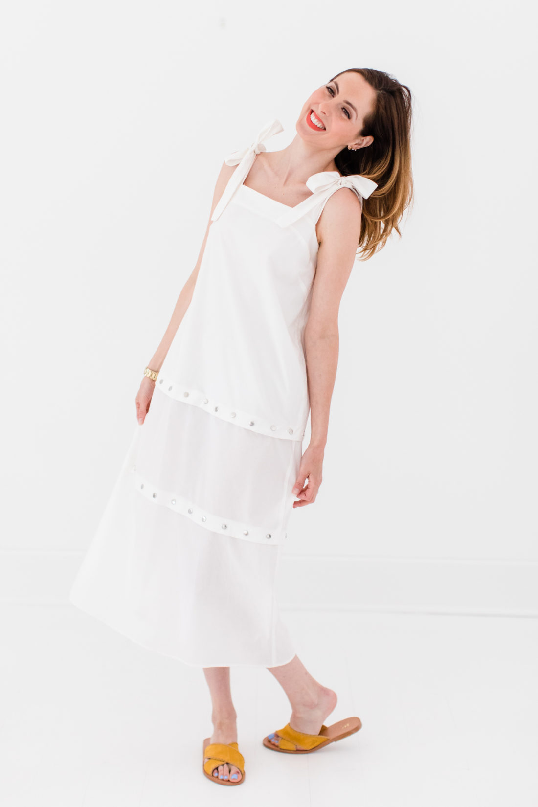Eva Amurri Martino wears an adjustable white snap dress with bow straps as part of a post about packing simply
