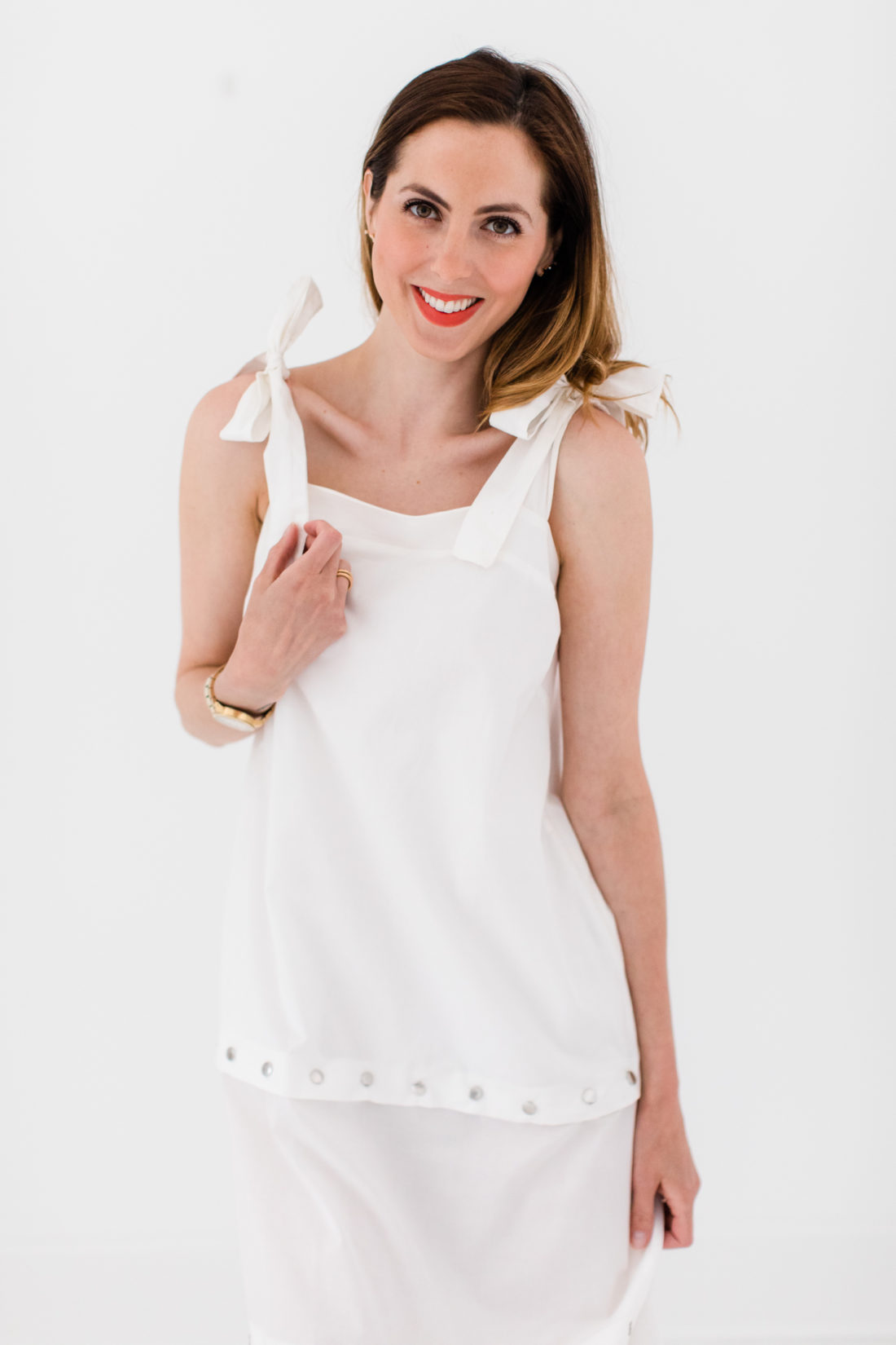 Eva Amurri Martino wears an adjustable white snap dress with bow straps as part of a post about packing simply