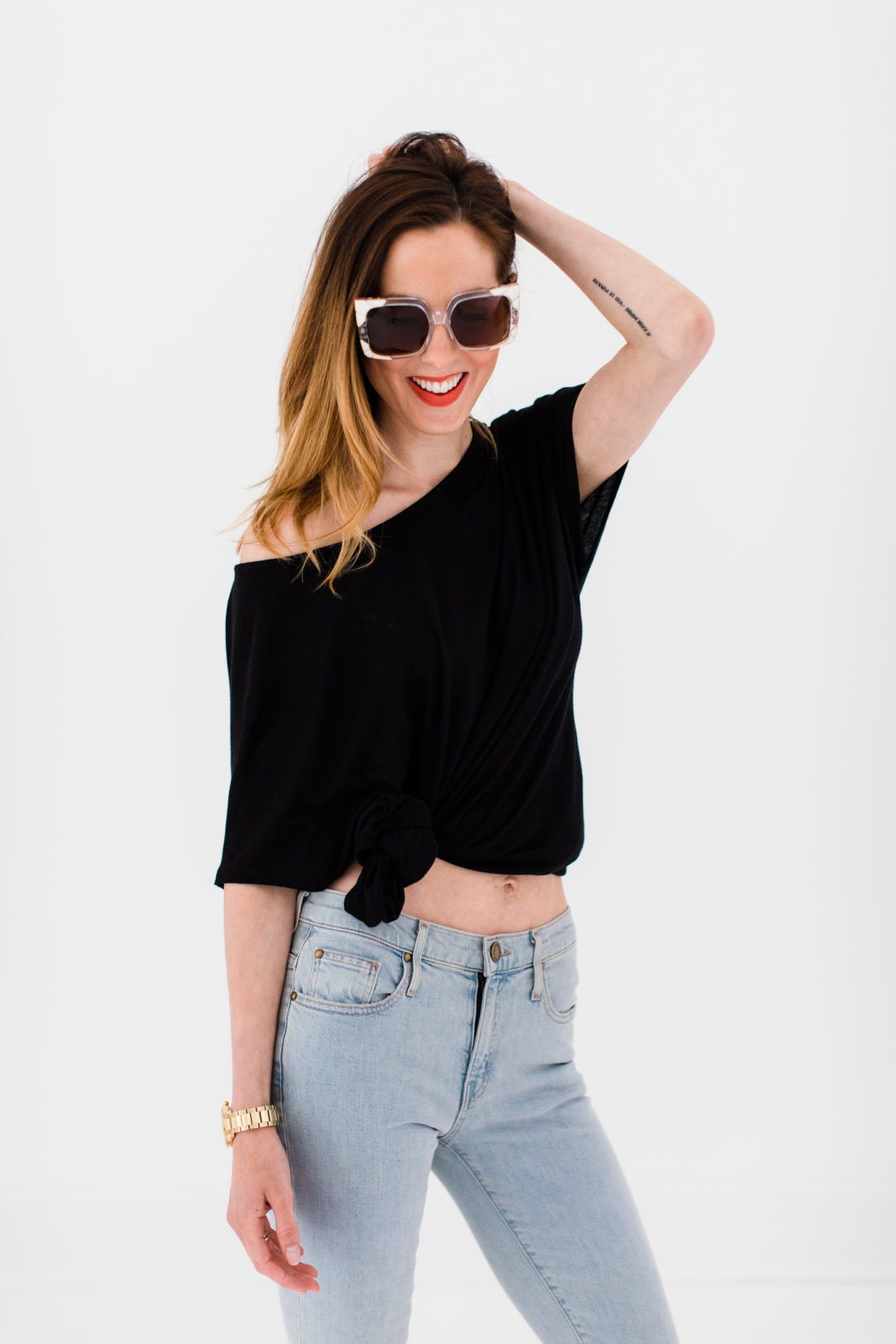 Eva Amurri Martino wears a black knotted top, jeans, and heels