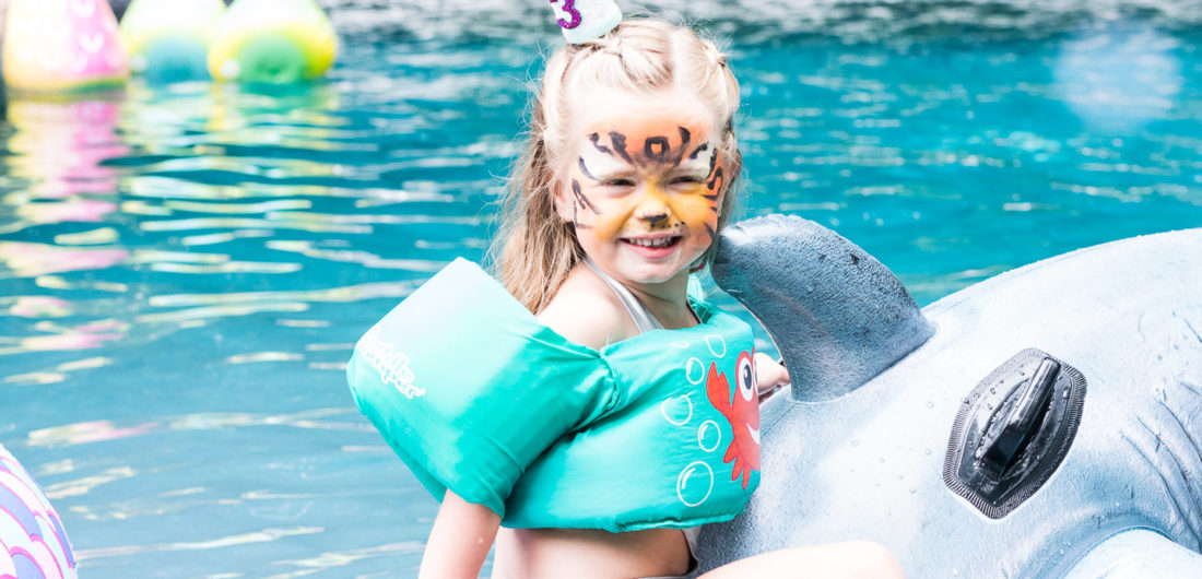Marlowe Martino rides on a shark pool float in the pool of her Connecticut home at her third birthday party