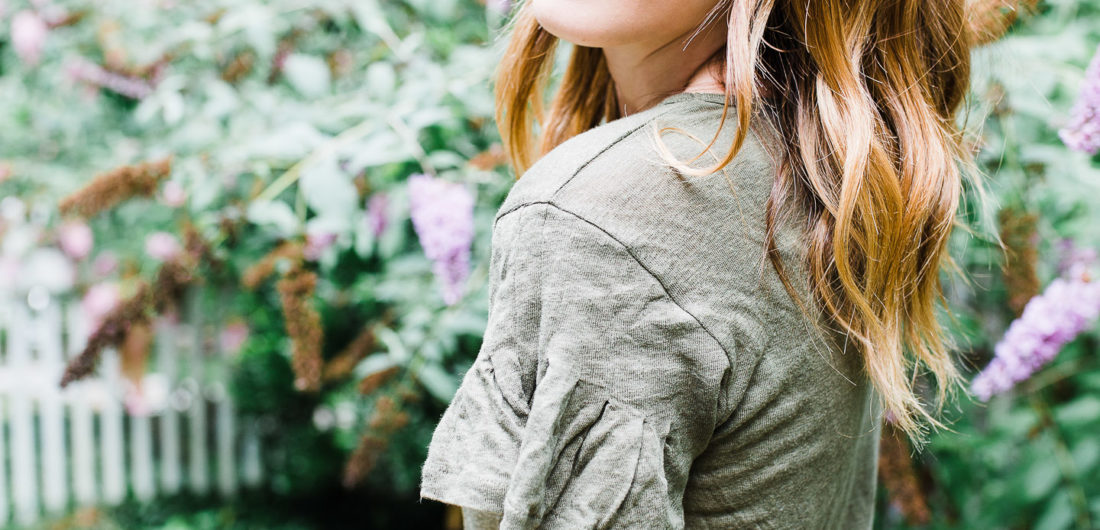 Eva Amurri Martino wears an army green flutter sleeve linen Tshirt in the courtyard of her Connecticut home