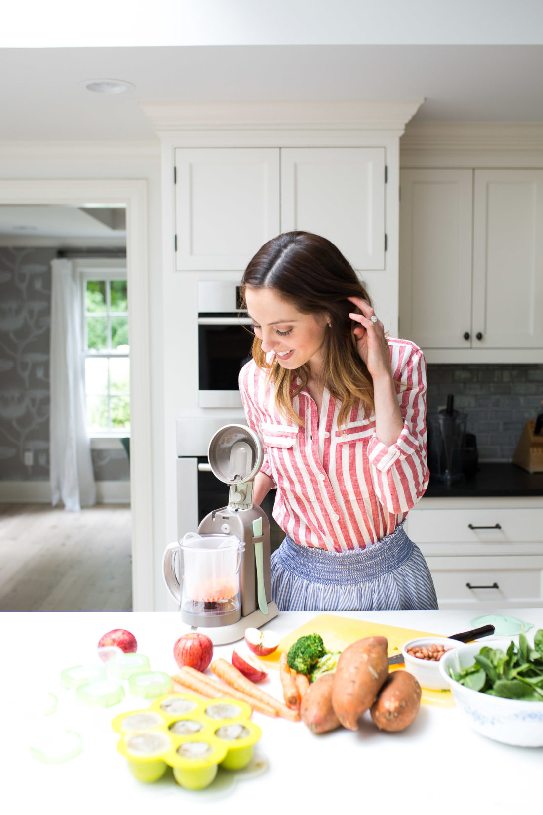 Eva Amurri Martino drops chopped carrots in to the steamer of her beaba babycook pro baby food maker
