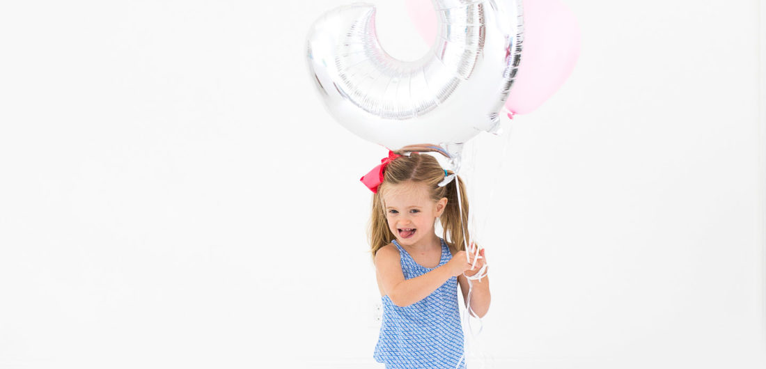 Marlowe Martino poses with a large balloon for her third birthday portraits