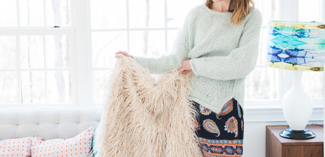 Eva Amurri Martino holds up a fuzzy shag throw blanket in her studio