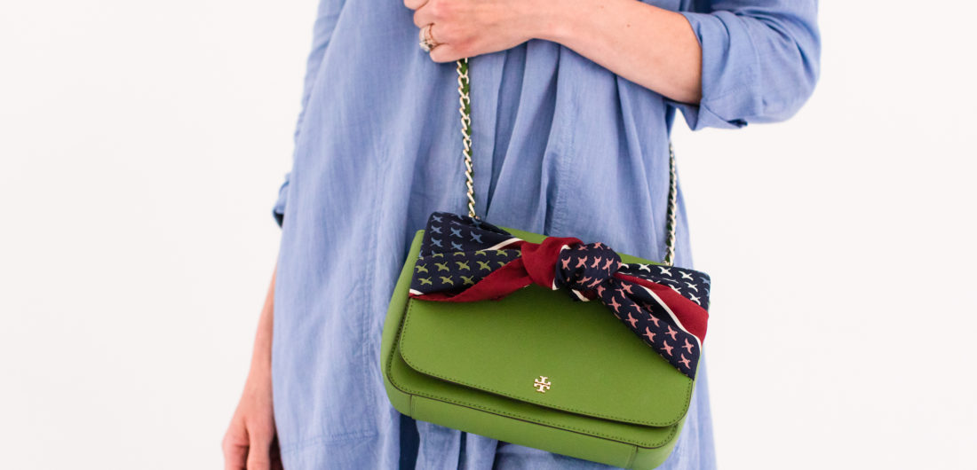 Eva Amurri Martino wears a blue shirt dress and styles a silk scarf to adorn her green tory burch bag