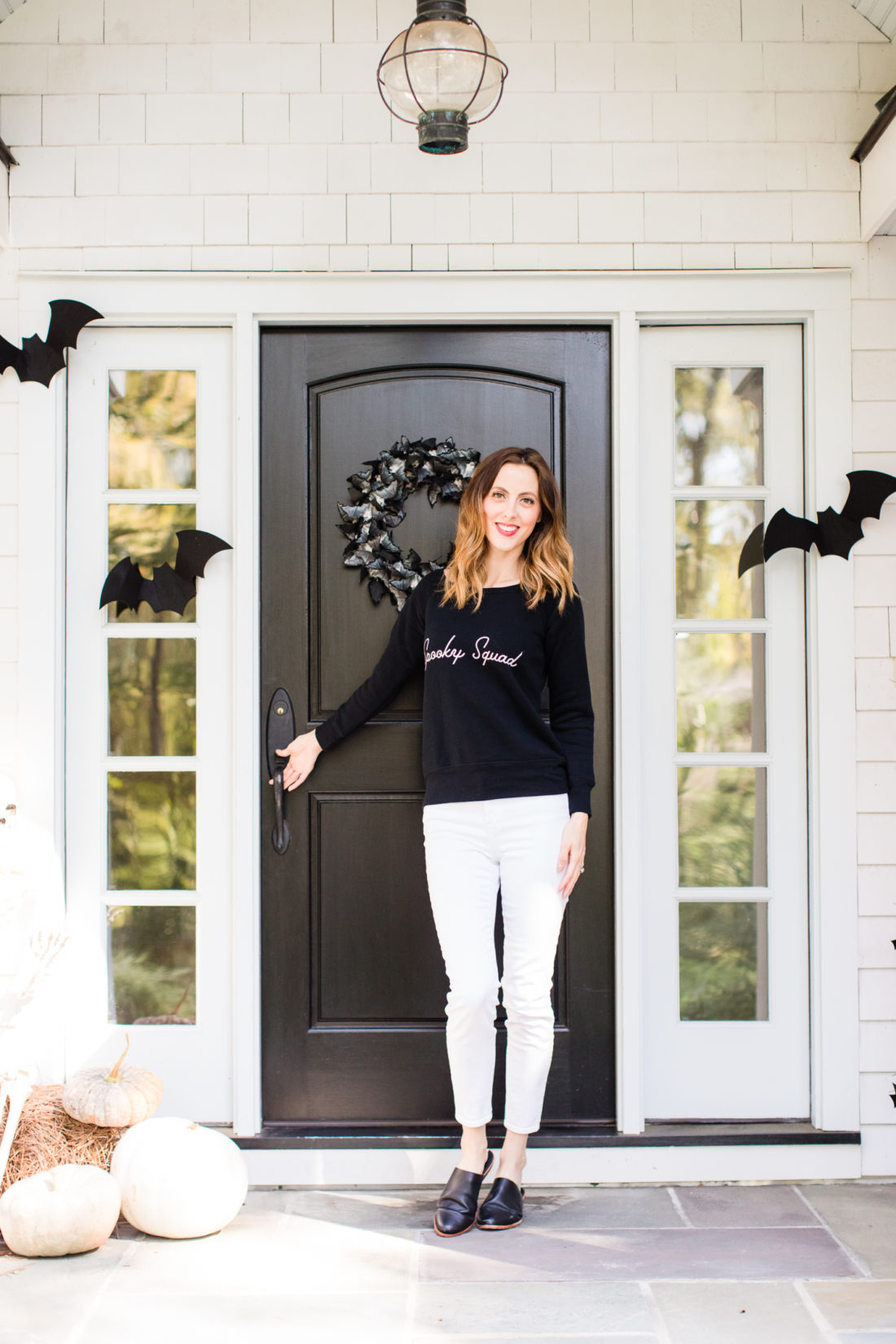 Eva Amurri Martino stands at the entryway to her Connecticut home that is decorated with a spooky bat theme for Halloween