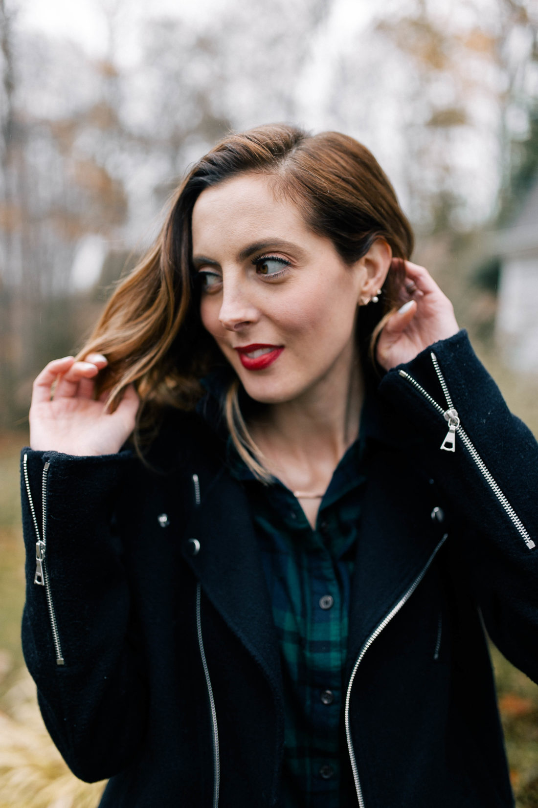 Eva Amurri Martino wears a plaid top, navy blue jacket, corduroy skirt, and black booties and walks down the pathway to her Connecticut home