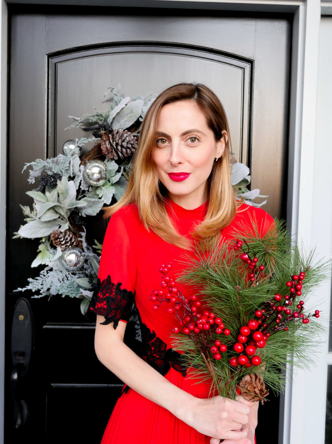 Eva Amurri Martino wears a festive red dress with black lace detailing for a holiday party