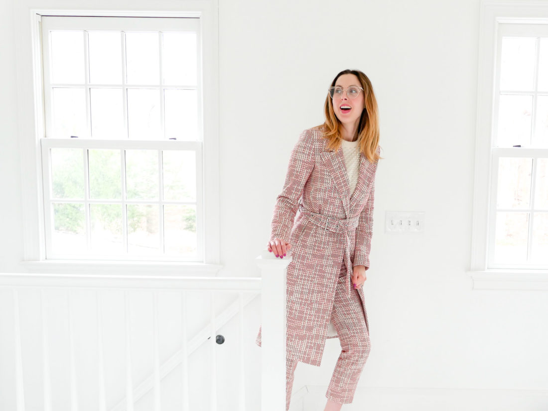 EVa Amurri Martino wears a red, white and black patterned coat and matching trousers, and walks up the stairs of her Connecticut home