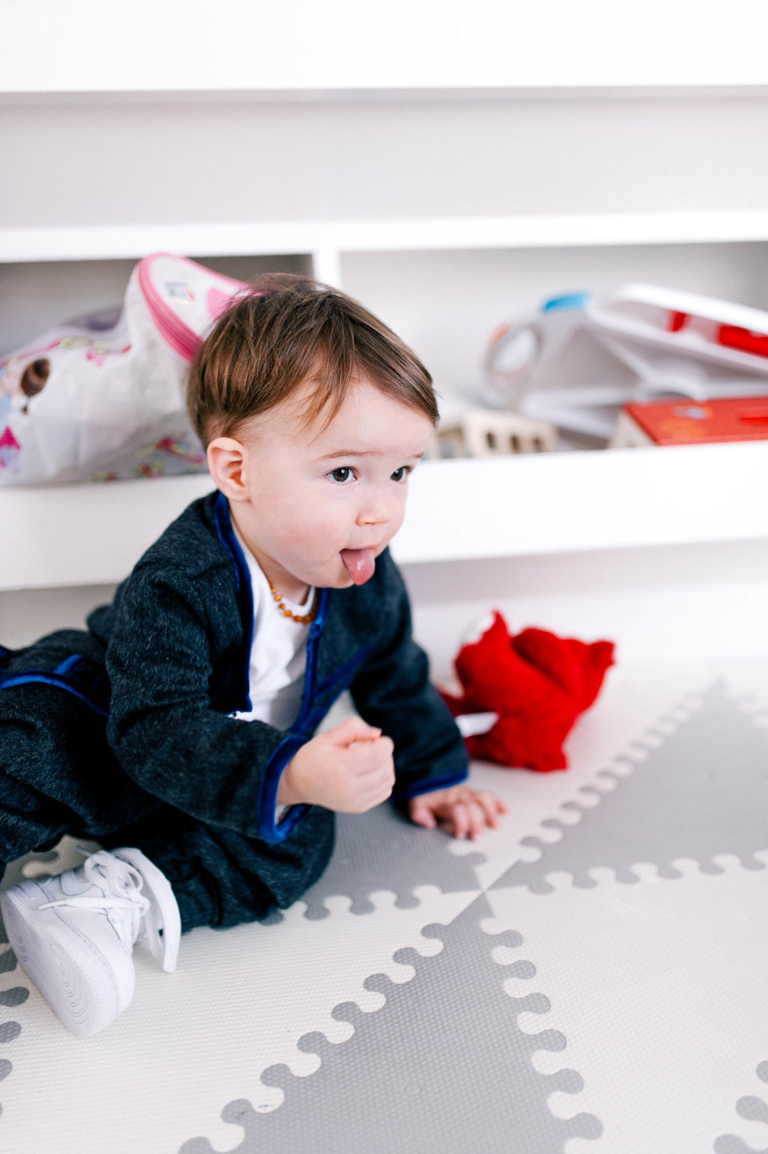 Major Martino wears a white tshirt and a grey mohair jacket and plays in the family room on a rubber playmat
