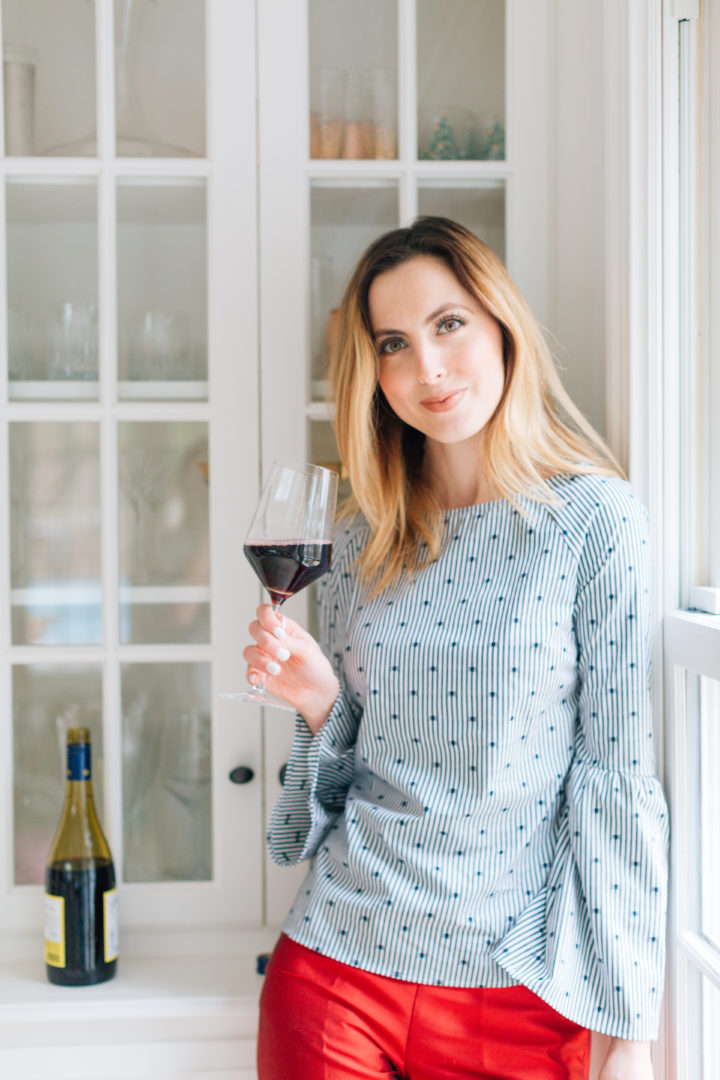 Eva Amurri Martino sips on a glass of red wine in a blue top at her Connecticut home