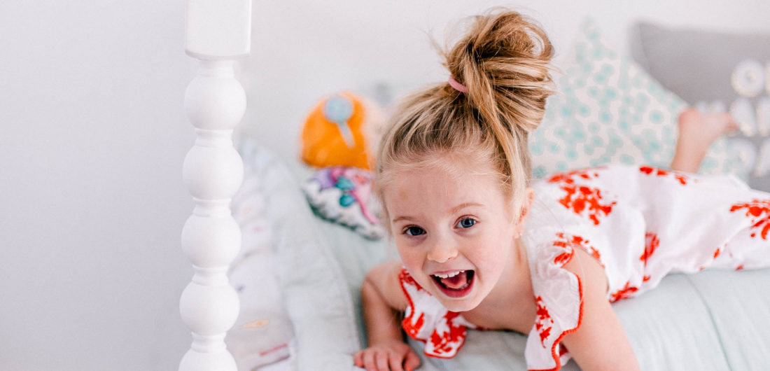 Eva Amurri Martino's daughter Marlowe lies on her bed in a topknot a bright dress