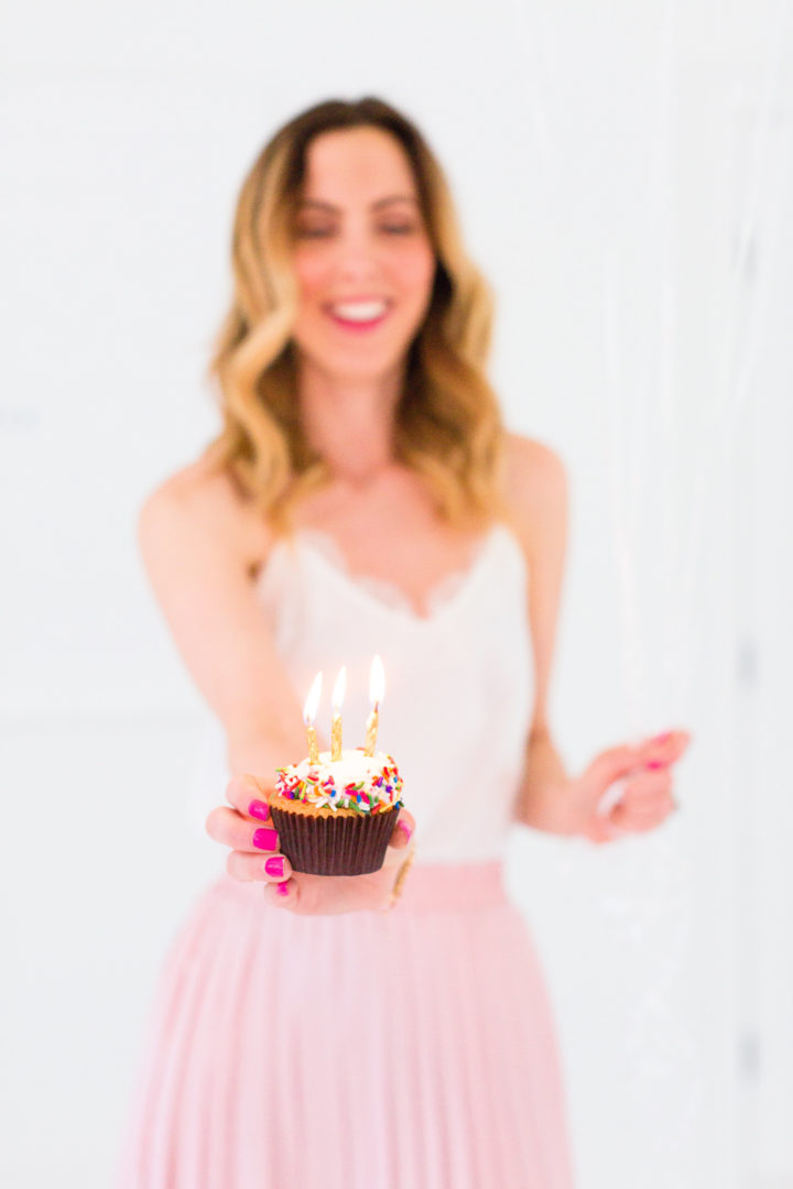 Eva Amurri Martino holds a cupcake with a candle to commemorate the 3rd birthday of her blog REZTT