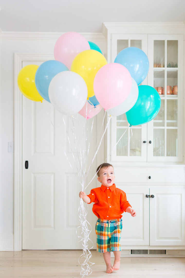 Eva Amurri Martino's son Major wears a colorful outfit while holding a handful of multicolored balloons in their Connecticut home.