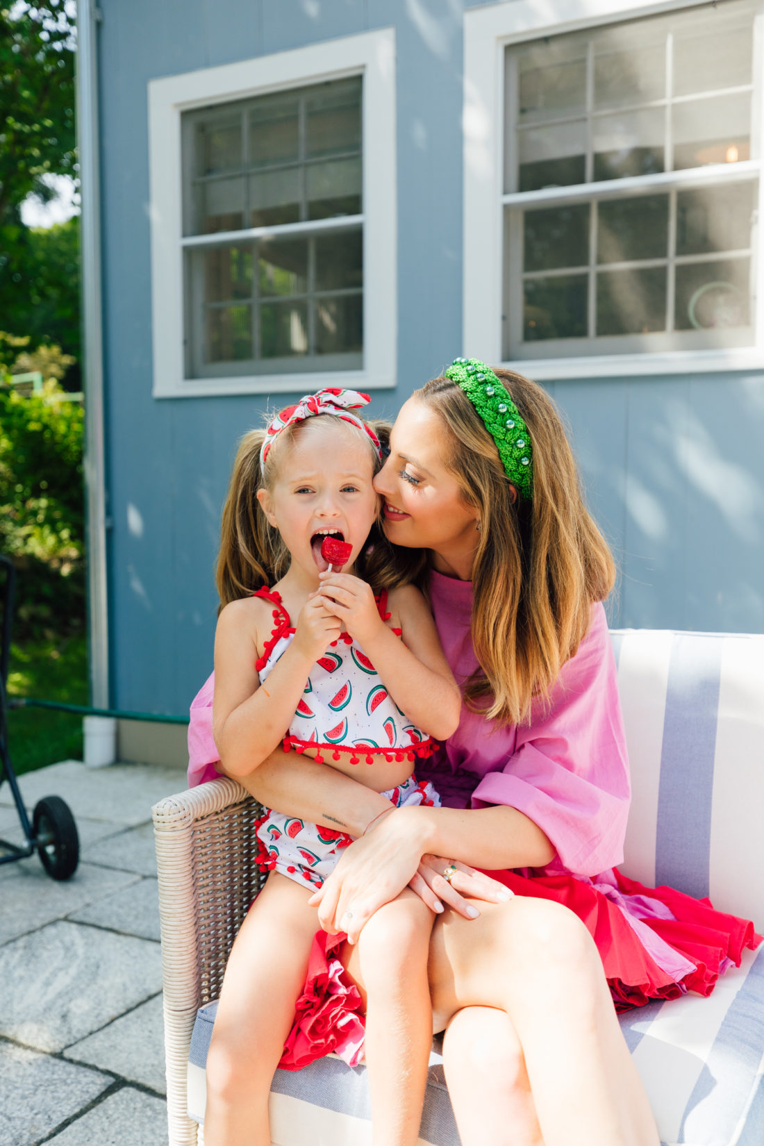 Marlowe Martino sits on mom Eva Amurri Martino's lap eating a watermelon lollipop
