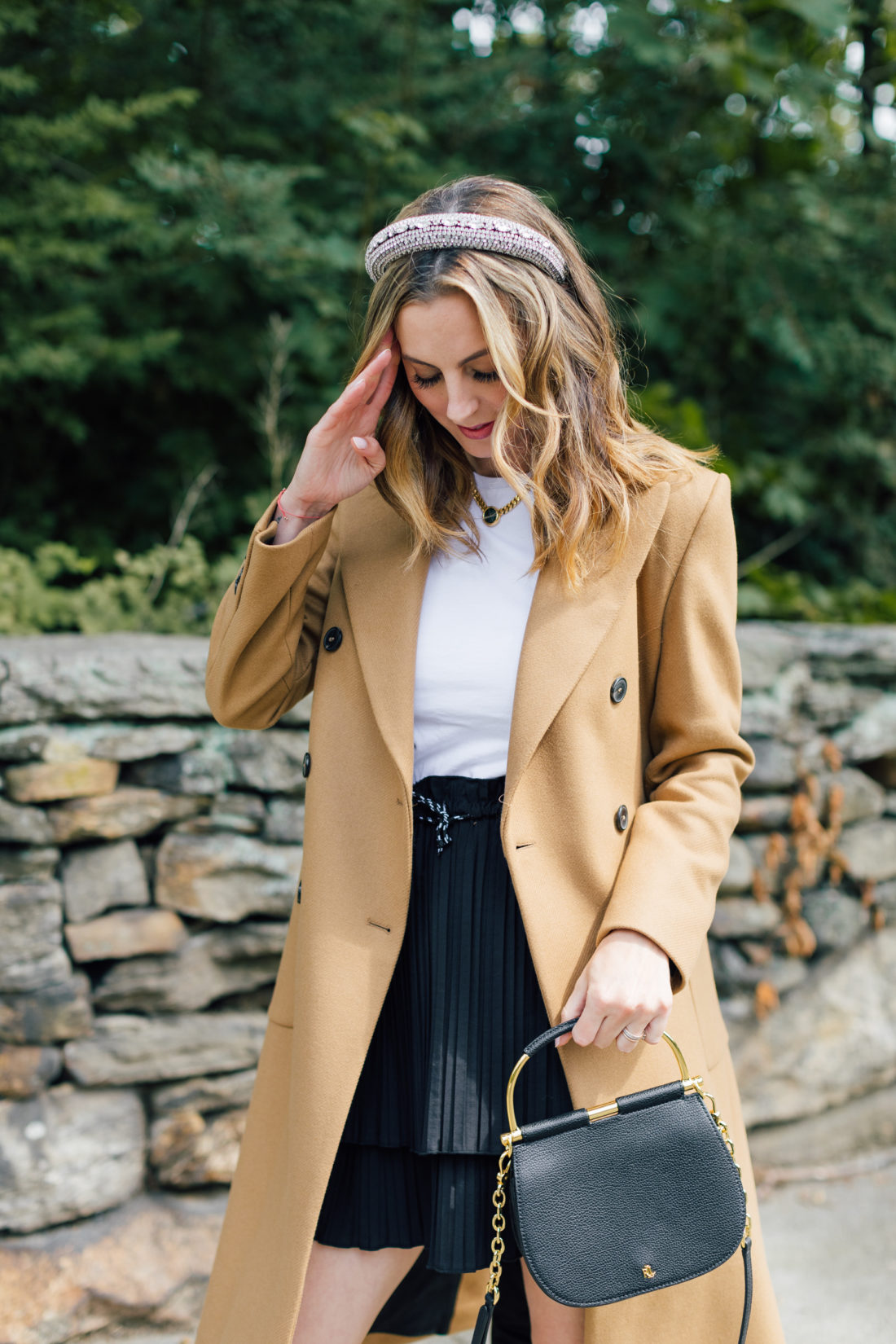 Eva Amurri Martino wears a camel coat, a black skirt and a white top as a neutral color palette