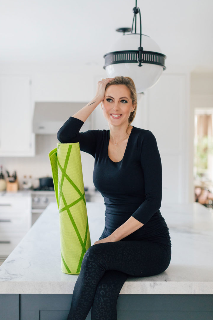 Eva Amurri sits on her kitchen island in her Connecticut home while holding a foam roller