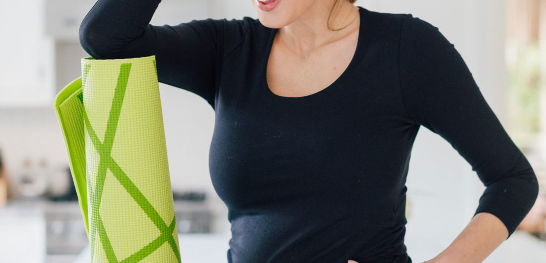 Eva Amurri sits on her kitchen island in her Connecticut home while holding a foam roller