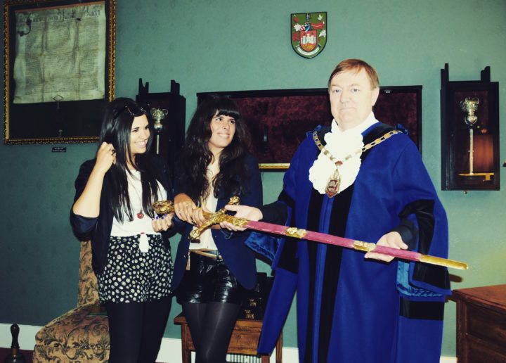 Eden Cale holds Henry VII's sword with visual artist Swci Delic and the Sheriff of Carmarthen Alun Lenny
